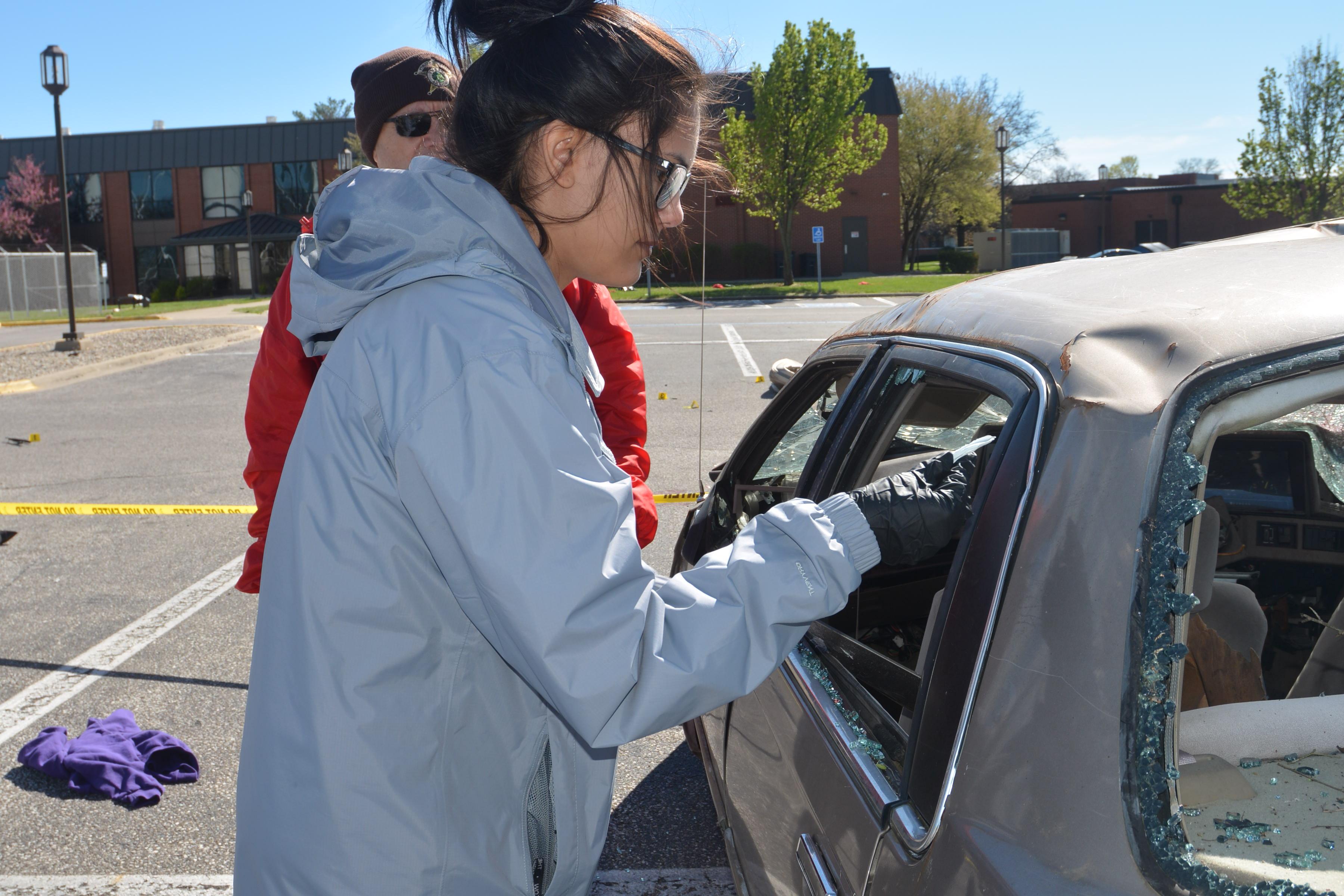 Conservation Law student inspecting car wreck.