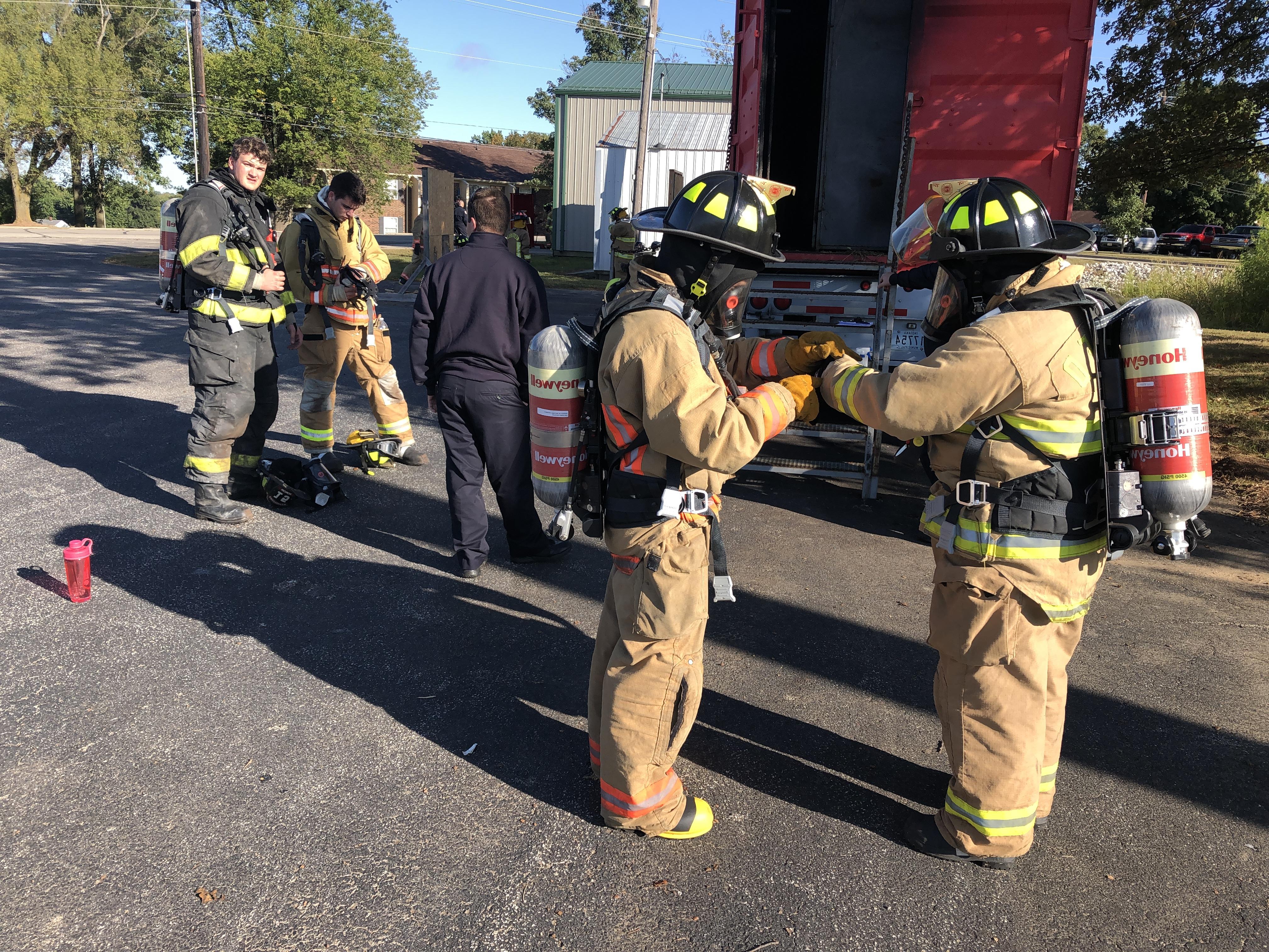 fire fighter helping with gear